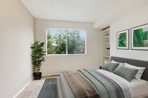 Northridge apartment for rent - A bedroom with a large bed and a potted plant.