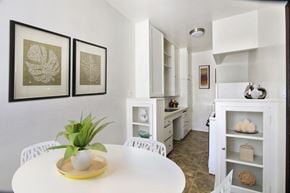 Beverly Hills apartment for rent - A white table with a plant on it and two framed pictures on the wall.
