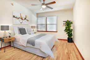 Valley Village apartment for rent - A bedroom with a bed, a ceiling fan, and a potted plant.