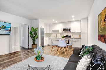 Canoga Park apartment for rent - A modern living room with a grey sofa and a coffee table with flowers on it.