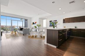 Culver City apartment for rent - A modern kitchen with dark wood floors and white chairs.