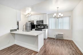 Van Nuys apartment for rent - an open kitchen and living room with a white counter top and a refrigerator