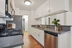 Los Angeles apartment for rent - A kitchen with white cabinets and a black stove top.