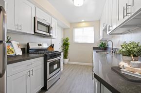 Los Angeles apartment for rent - A modern kitchen with white cabinets and a black stove top.