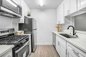 Tarzana apartment for rent - a white kitchen with stainless steel appliances and white cabinets