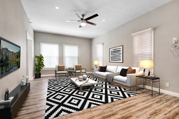 Los Angeles apartment for rent - A living room with a black and white rug, a white couch, and a painting on the wall.