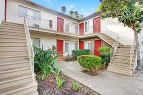 Sherman Oaks apartment for rent - A building with red doors and a tree in front.