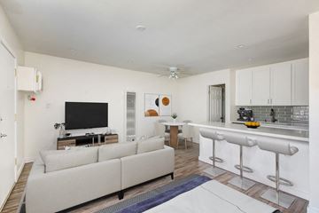 Van Nuys apartment for rent - A modern living room with a white couch and a bar area.