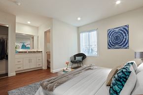 Van Nuys apartment for rent - A bedroom with a large bed and a blue artwork on the wall.