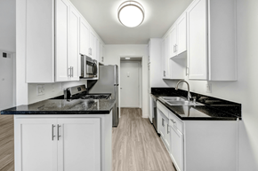 Northridge apartment for rent - a white kitchen with white cabinets and black counter tops