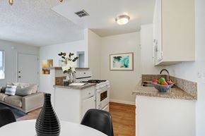 Canoga Park apartment for rent - A kitchen with a table and chairs in the foreground.