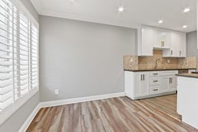 Studio City apartment for rent - A kitchen with white cabinets and a wooden floor.