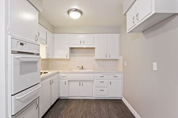 Glendora apartment for rent - A white kitchen with wood flooring and a white refrigerator.