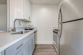 Los Angeles apartment for rent - A kitchen with a stainless steel refrigerator and a sink with a faucet.