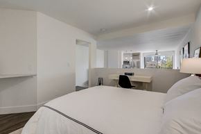 Los Angeles apartment for rent - A bedroom with a large bed and a desk with a chair.