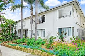 West Hollywood apartment for rent - A white two-story building with a garden in front.