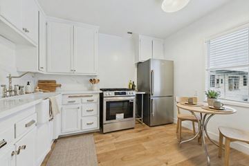 West Hollywood apartment for rent - A kitchen with white cabinets and a stainless steel refrigerator.