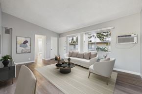 North Hollywood apartment for rent - A living room with a grey sofa, a coffee table, and a painting on the wall.