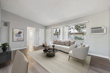North Hollywood apartment for rent - A living room with a grey sofa, a coffee table, and a painting on the wall.
