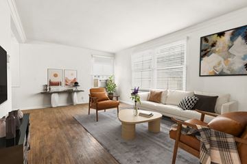 West Hollywood apartment for rent - A living room with a brown leather chair and a grey rug.
