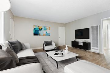 Los Angeles apartment for rent - A living room with a grey couch, a white armchair, a coffee table, and a painting on the wall.
