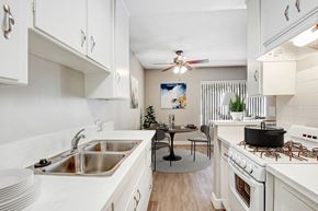 Los Angeles apartment for rent - A kitchen with white cabinets and a black table.