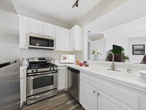 Hancock Park apartment for rent - A modern kitchen with white cabinets and stainless steel appliances.