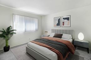Northridge apartment for rent - an example of a bedroom with a bed and a potted plant