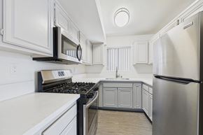 North Hollywood apartment for rent - A modern kitchen with white cabinets and stainless steel appliances.