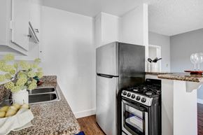 Los Angeles apartment for rent - A kitchen with a black stove top oven and a white refrigerator.