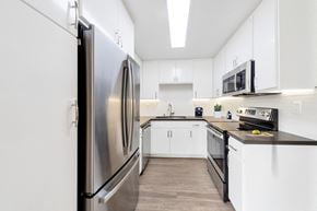 Burbank apartment for rent - A modern kitchen with a stainless steel refrigerator and black countertops.