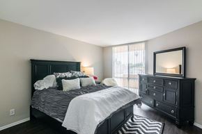 Los Angeles apartment for rent - A bedroom with a large bed and a dresser with a mirror.