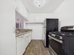 Los Angeles apartment for rent - A kitchen with a black stove and white cabinets.