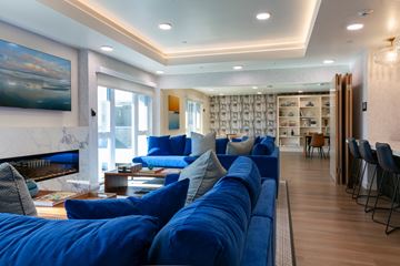 Canoga Park apartment for rent - A living room with a blue couch and a painting on the wall.