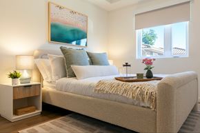 Canoga Park apartment for rent - A bedroom with a large bed, a nightstand with a lamp, and a painting on the wall.