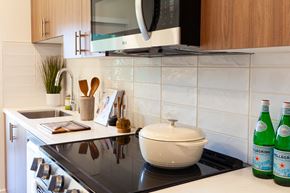 Canoga Park apartment for rent - A kitchen with a black countertop and white tiles.