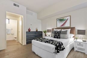 Century City apartment for rent - A bedroom with a large bed and a painting above it.