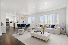 Beverly Hills apartment for rent - A modern living room with a white sofa, a white coffee table, and a white rug.