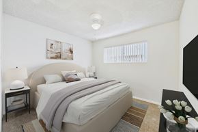 Canoga Park apartment for rent - A bedroom with a large bed and a nightstand with a lamp.