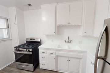 Los Angeles apartment for rent - A kitchen with white cabinets and a black stove.
