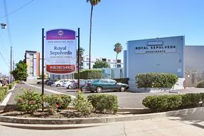 Van Nuys apartment for rent - A sign for Royal Sepulveda Apartments is displayed in front of a building.