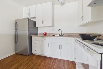 Panorama City apartment for rent - A kitchen with white cabinets and a stainless steel refrigerator.