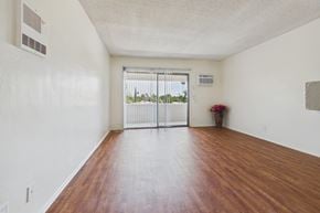 Panorama City apartment for rent - A room with a wooden floor and a sliding glass door.