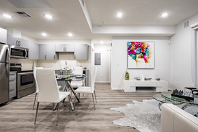 Van Nuys apartment for rent - Luxurious interior of a unit, living room in the right, dining area, Open kitchen on the left with stainless steel appliances, laminate flooring throughout, recessed lighting