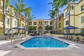 Chatsworth apartment for rent - A pool surrounded by palm trees and lounge chairs.
