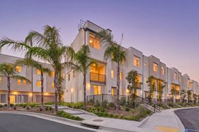 Granada Hills apartment for rent - A modern apartment complex with palm trees in front.
