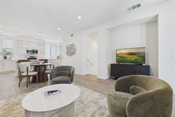 Granada Hills apartment for rent - A living room with a grey couch, a white coffee table, and a painting on the wall.