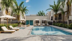 Granada Hills apartment for rent - A pool surrounded by palm trees and lounge chairs.