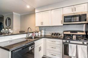 Los Angeles apartment for rent - A kitchen with white cabinets and a black stove top.