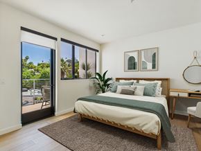 Los Angeles apartment for rent - A bedroom with a large bed and a view of the outside through the sliding glass doors.